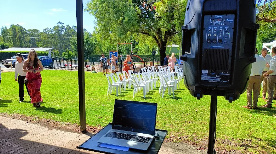 Portable ceremony speaker and DJ laptop set up beside the chairs for an outdoor wedding ceremony in Gippsland